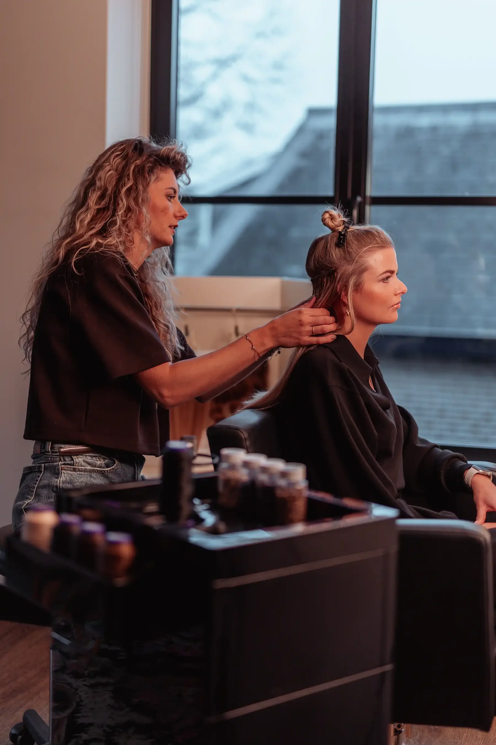 Stylist plaatst een weaving van Cèlia Blu in de salon