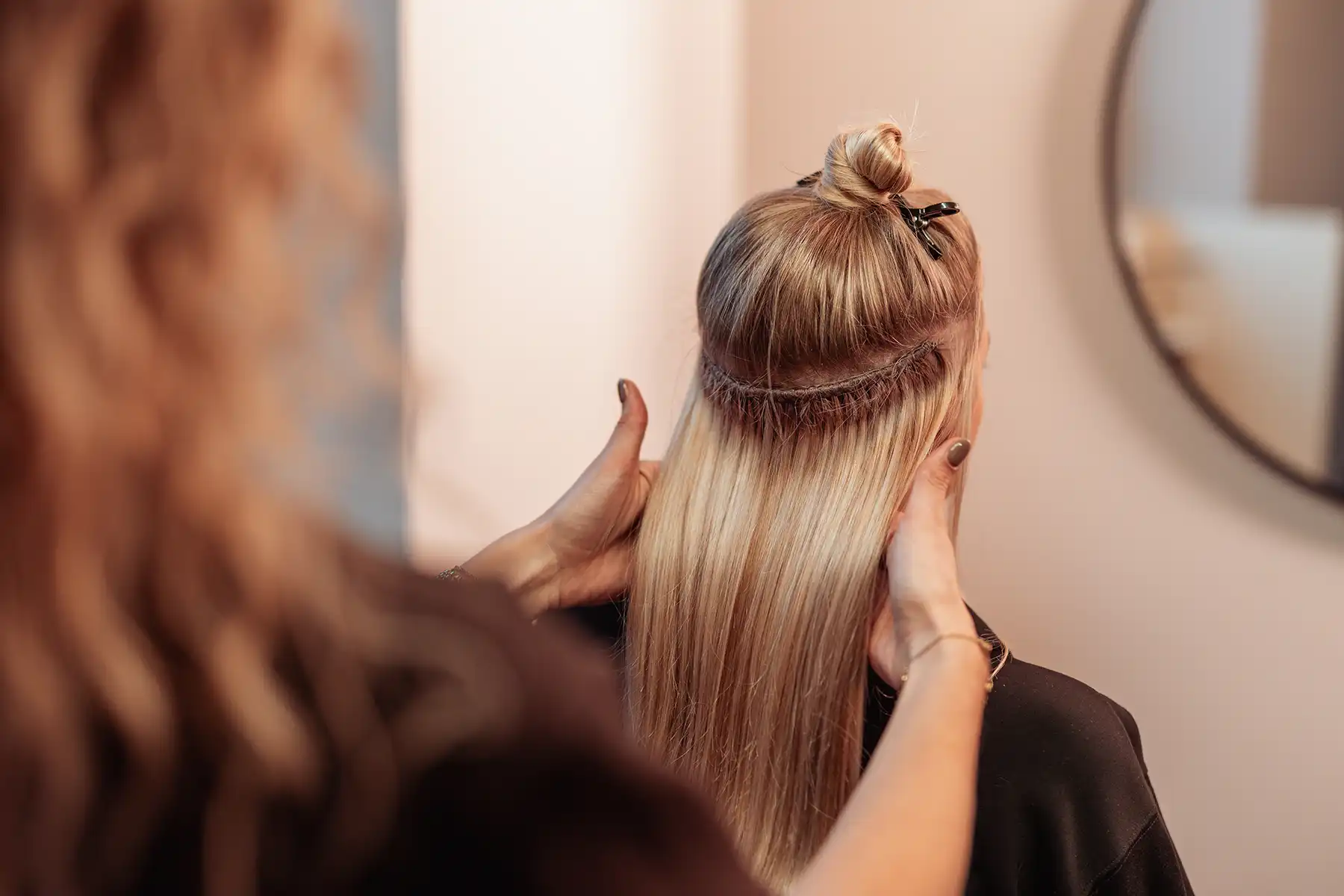 Stylist bevestigt een weaving van Cèlia Blu aan het eigen haar van een klant
