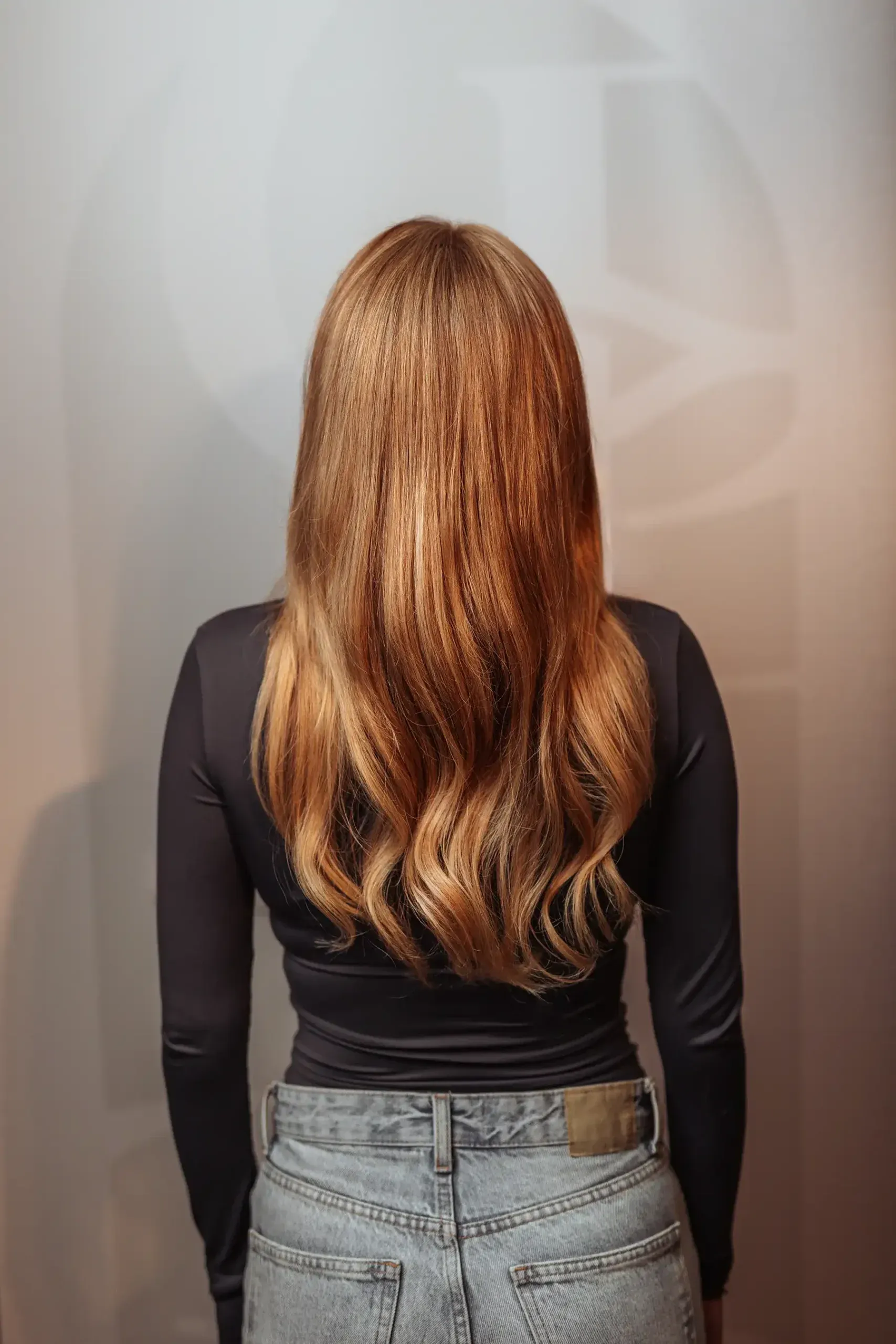 Na: langer koperkleurig haar met extra volume na de hybride haaroplossing