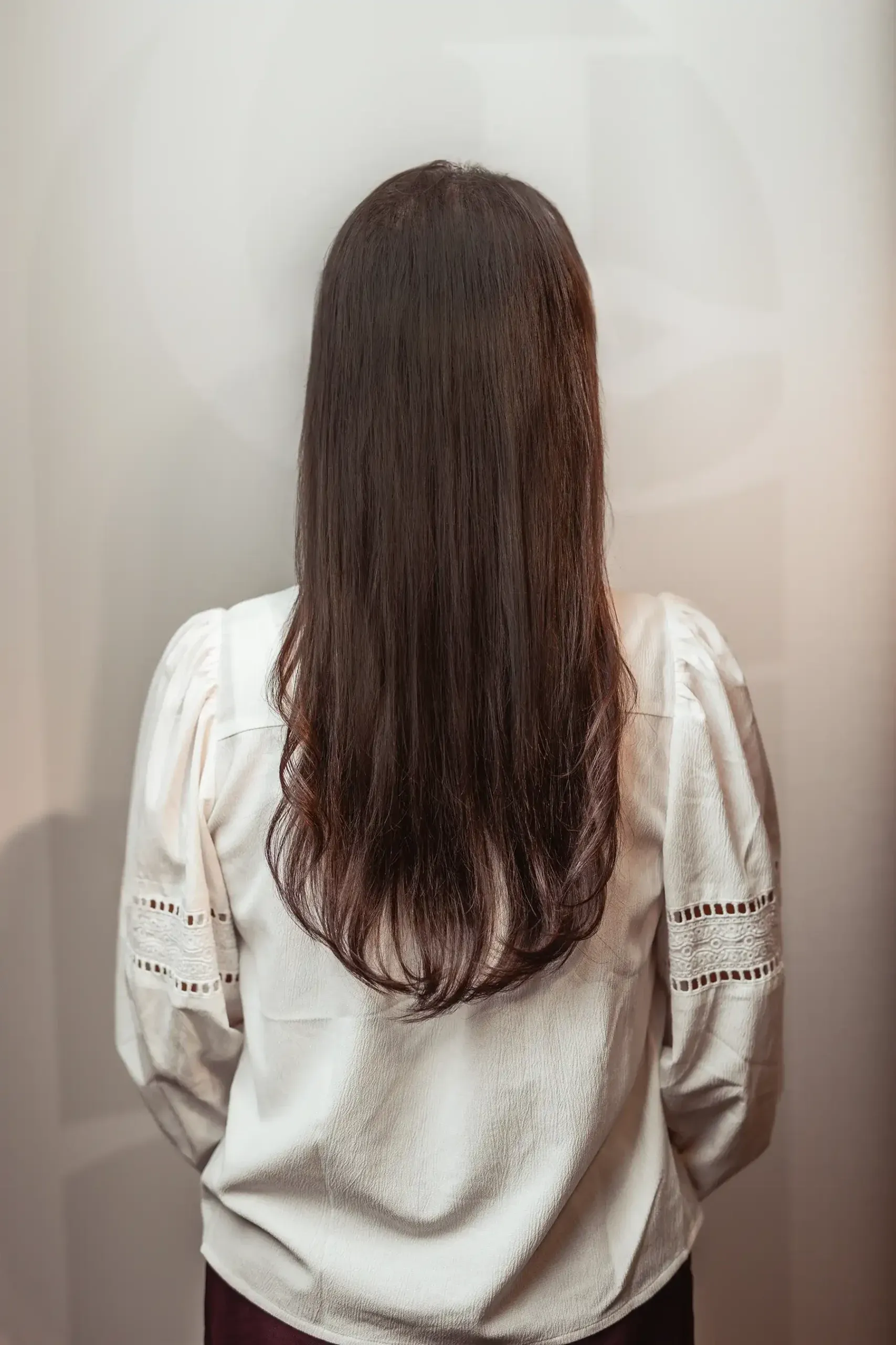 Na: klant met lang bruin haar na de medische haaroplossing